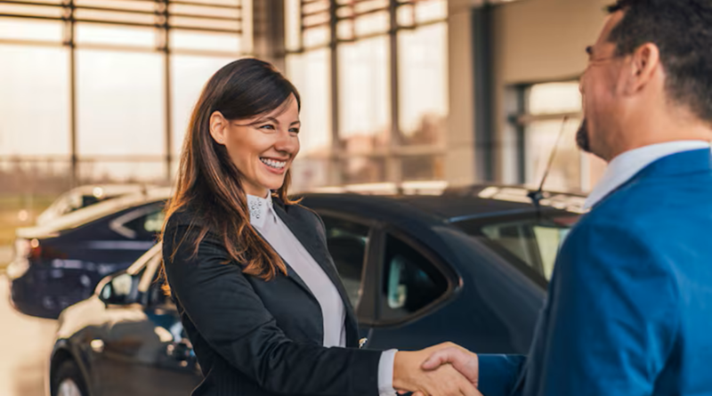 Concessionnaire de voitures souriant serrant la main d’un client dans une salle d’exposition automobile.