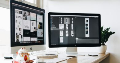 Poste de travail avec deux écrans affichant des projets graphiques, illustrant le travail d’un graphiste freelance.