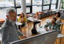 Dans une salle de classe moderne, un professeur explique à des étudiants dans un tableau
