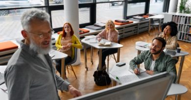 Dans une salle de classe moderne, un professeur explique à des étudiants dans un tableau