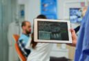 Dentiste tenant une tablette avec une radiographie, patient assis sur un fauteuil