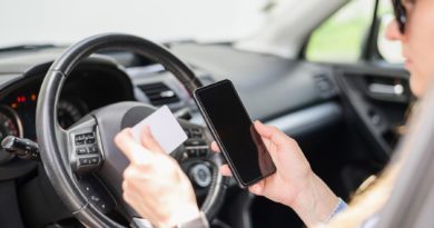 Femme assise dans une voiture tenant un smartphone et une carte