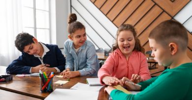 Quatre enfants travaillent ensemble à une table en classe.