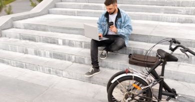 Homme travaillant sur son ordinateur portable à l'extérieur et buvant du café