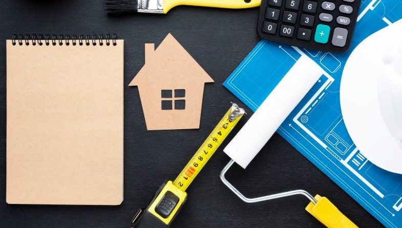 Impression bleue d'une maison avec des outils et un bloc-notes vide