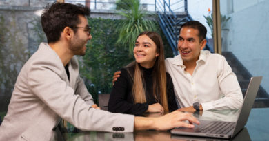 Conseiller indépendant échangeant avec un couple autour d'un laptop.