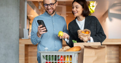 Un jeune couple souriant déballe ses courses de retour du marché