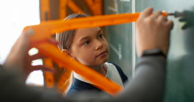 Écolière observant l'utilisation d'un compas géant au tableau