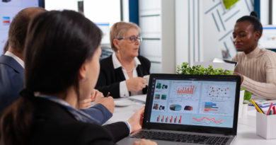 Réunion d'experts analysant des indicateurs financiers sur laptop.