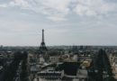 Vue panoramique sur les toits de Paris avec la Tour Eiffel s'élevant au centre sous un ciel nuageux