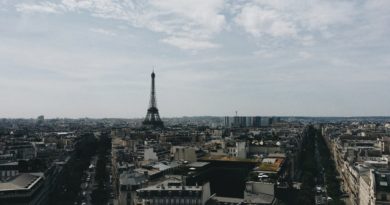 Vue panoramique sur les toits de Paris avec la Tour Eiffel s'élevant au centre sous un ciel nuageux
