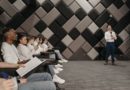 un orateur debout avec un microphone s'adressant à un public attentif assis dans une salle de conférence